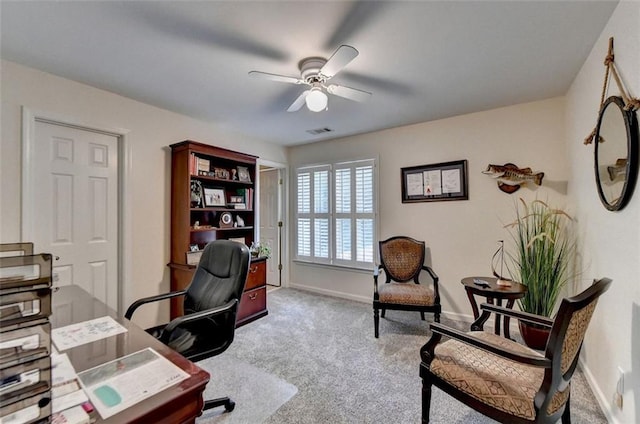 carpeted home office featuring ceiling fan