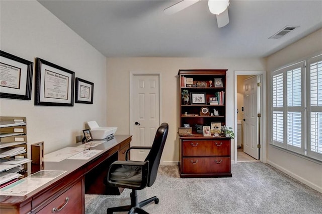 carpeted office space featuring ceiling fan