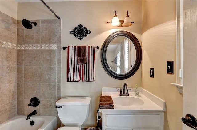 full bathroom featuring vanity, tiled shower / bath combo, and toilet