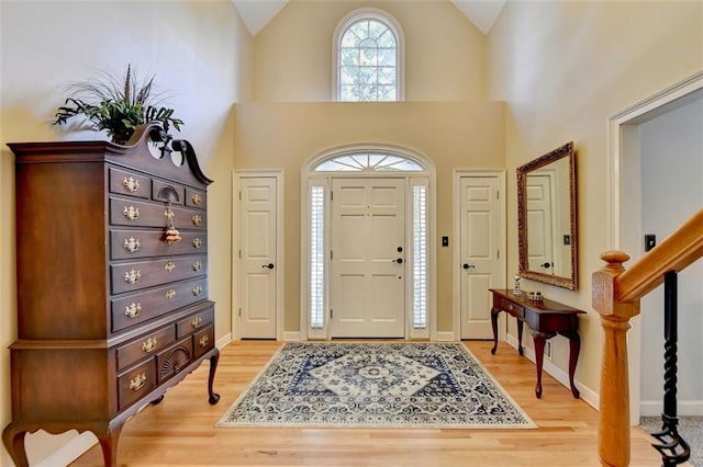 foyer entrance with hardwood / wood-style flooring and high vaulted ceiling