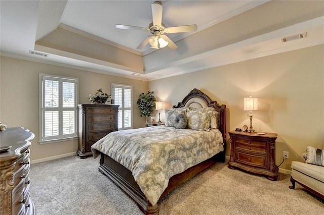 bedroom with ornamental molding, light colored carpet, a tray ceiling, and ceiling fan