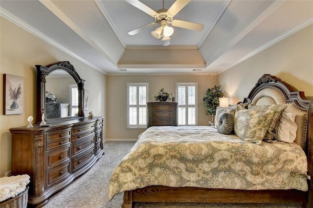 bedroom featuring crown molding, a raised ceiling, light colored carpet, and ceiling fan