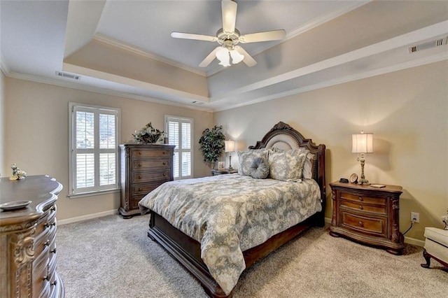 bedroom with ceiling fan, light carpet, a tray ceiling, and crown molding