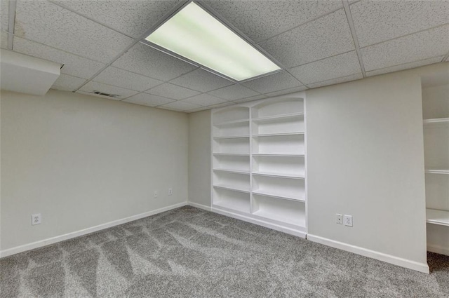 interior space with a paneled ceiling and carpet flooring