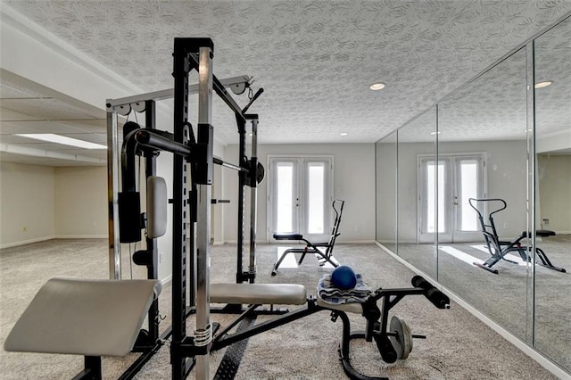 exercise room featuring french doors, light carpet, a textured ceiling, and a wealth of natural light