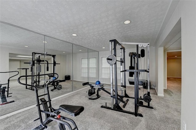 exercise room featuring light carpet and a textured ceiling