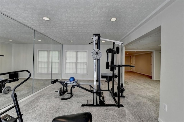 workout area featuring a textured ceiling and carpet flooring