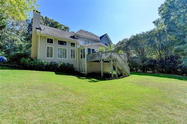 rear view of property with a deck and a yard