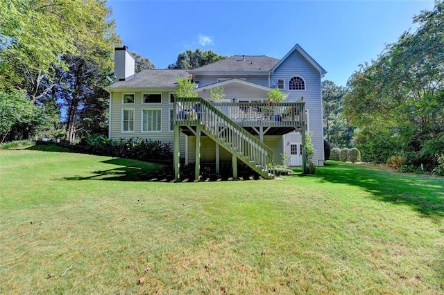 rear view of house with a deck and a yard