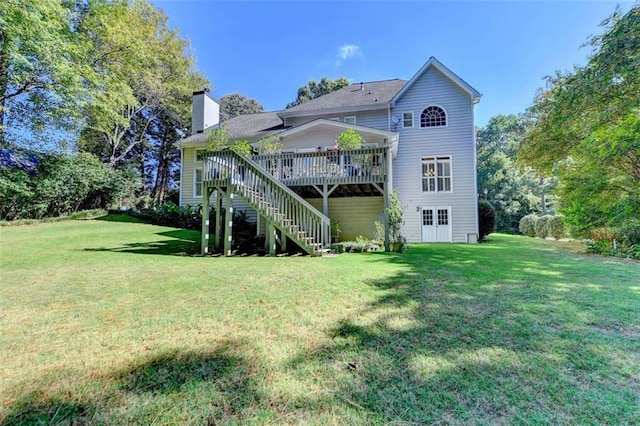 rear view of house featuring a yard and a deck