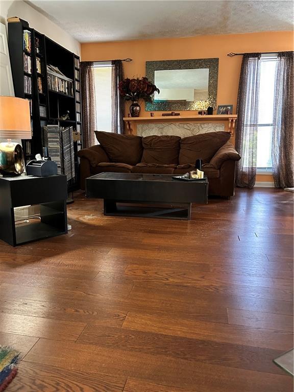 living area with a textured ceiling and wood finished floors