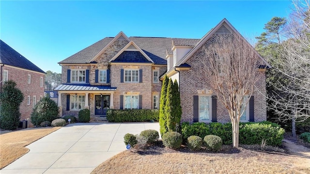 view of front of home featuring driveway, a porch, and brick siding