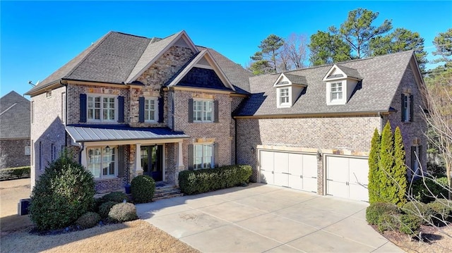 view of front of house featuring driveway, a shingled roof, an attached garage, and brick siding