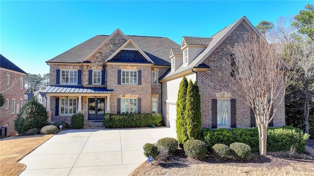 view of front of home with central AC, concrete driveway, and brick siding