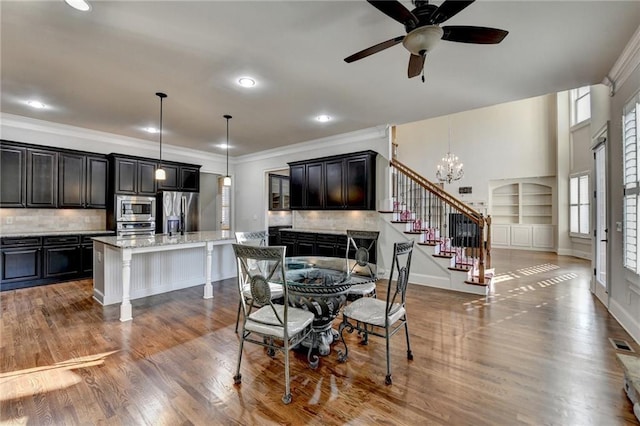 dining room with ornamental molding, visible vents, stairway, and wood finished floors