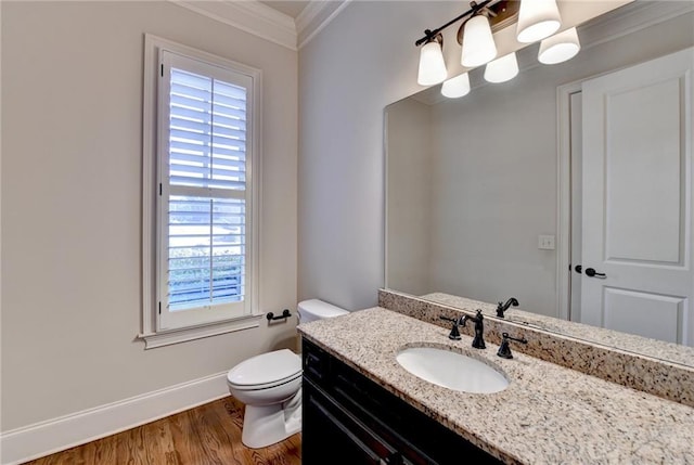 bathroom with toilet, wood finished floors, vanity, baseboards, and ornamental molding