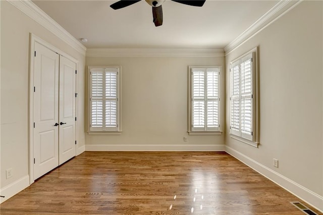 unfurnished bedroom featuring visible vents, crown molding, and wood finished floors