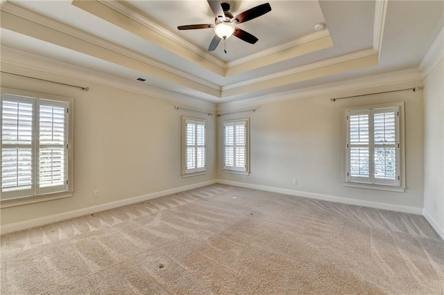 spare room with light carpet, a raised ceiling, visible vents, and a healthy amount of sunlight