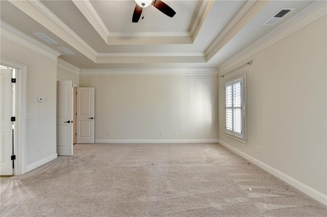 unfurnished room with visible vents, ornamental molding, a tray ceiling, and carpet flooring