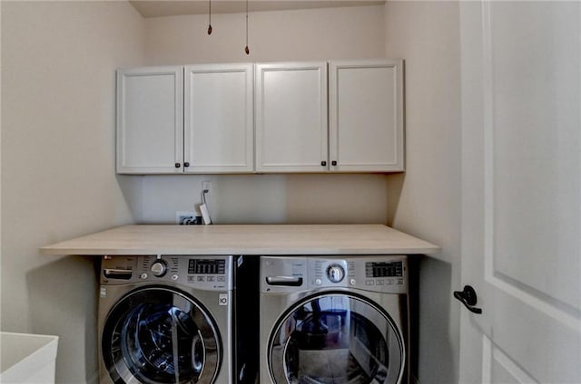 laundry room featuring independent washer and dryer and cabinet space