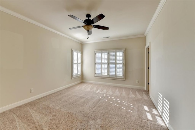 spare room with ornamental molding, light colored carpet, and baseboards