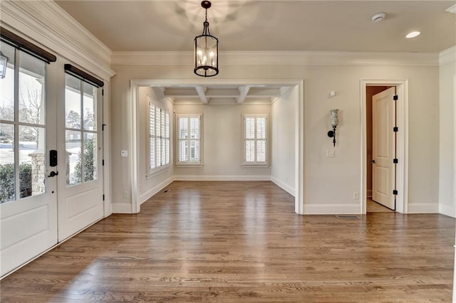 entrance foyer featuring ornamental molding, wood finished floors, beam ceiling, and baseboards