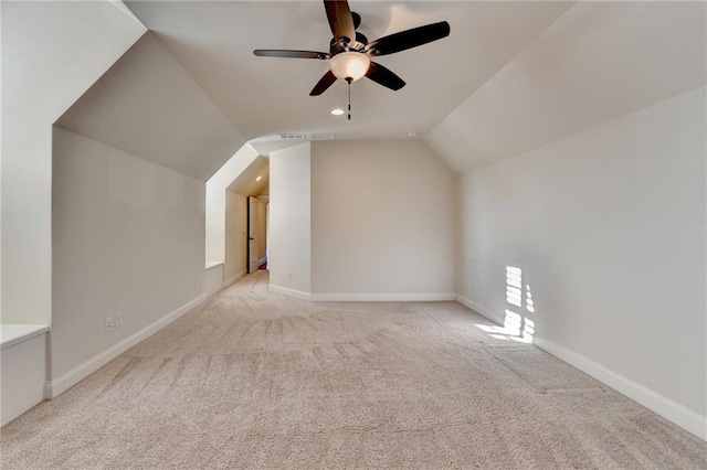 additional living space with light carpet, vaulted ceiling, baseboards, and ceiling fan