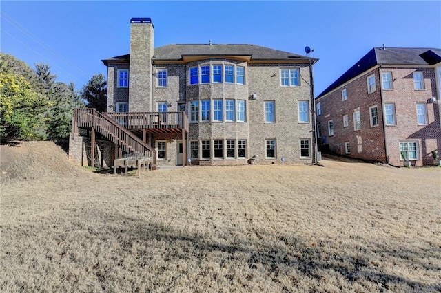 back of house featuring stairs, a chimney, and a wooden deck