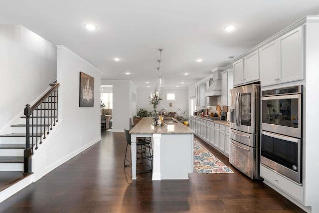 3692 Wartrace Dr, South Fulton, GA 30331 - kitchen featuring appliances with stainless steel finishes, an island with sink, a kitchen bar, dark wood-style floors, and recessed lighting