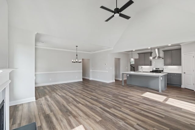 unfurnished living room featuring high vaulted ceiling, ceiling fan with notable chandelier, sink, crown molding, and dark hardwood / wood-style flooring