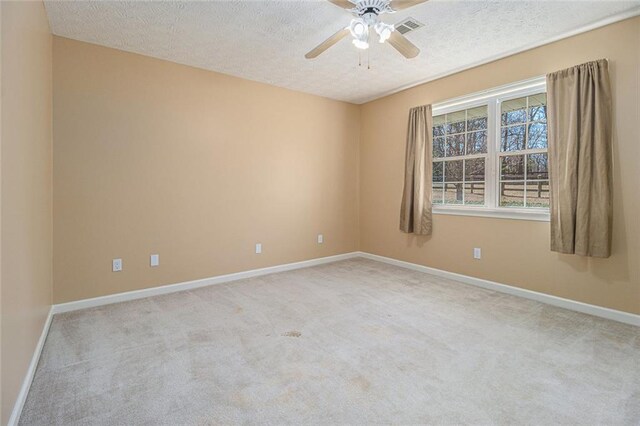 carpeted empty room featuring a textured ceiling, baseboards, visible vents, and a ceiling fan