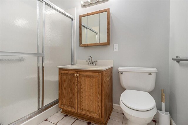 full bathroom with a stall shower, tile patterned flooring, vanity, and toilet