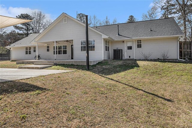 back of house with a shingled roof, a lawn, a ceiling fan, a patio, and fence