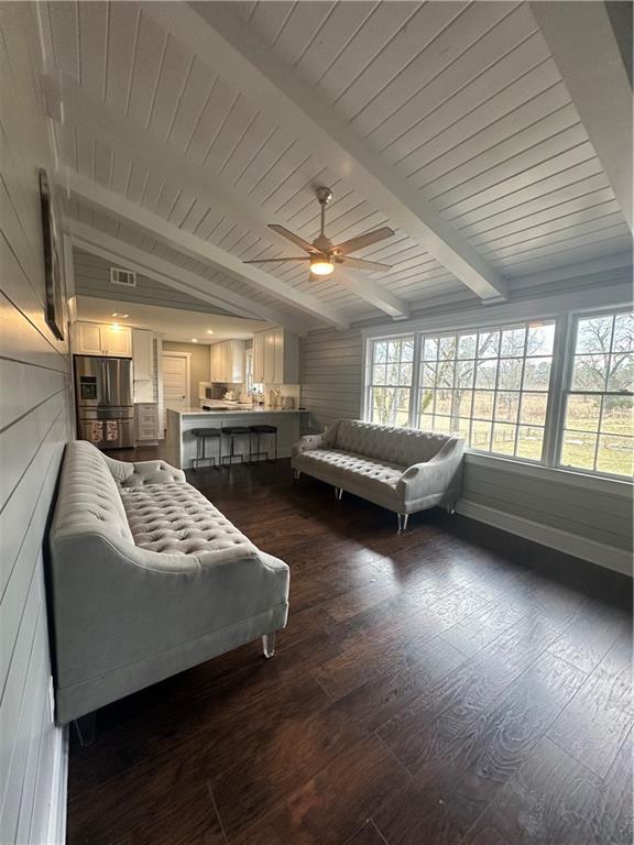 bedroom with dark wood-type flooring, lofted ceiling with beams, wooden ceiling, and stainless steel fridge