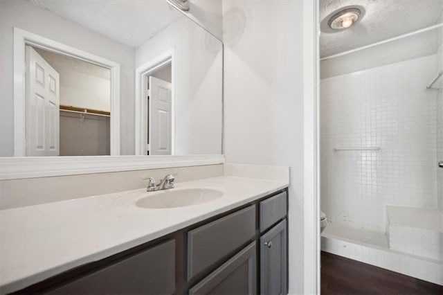 5555 Mountain Springs Cir, Stone Mountain, GA 30088 - full bath with tiled shower, vanity, toilet, wood finished floors, and a textured ceiling