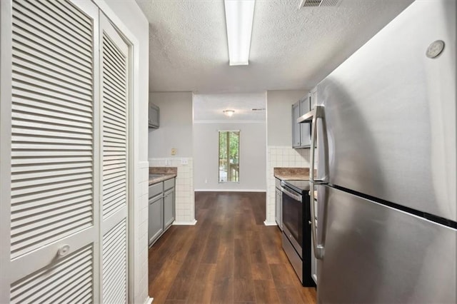 5555 Mountain Springs Cir, Stone Mountain, GA 30088 - kitchen featuring stainless steel appliances, gray cabinets, a textured ceiling, decorative backsplash, and dark wood-type flooring