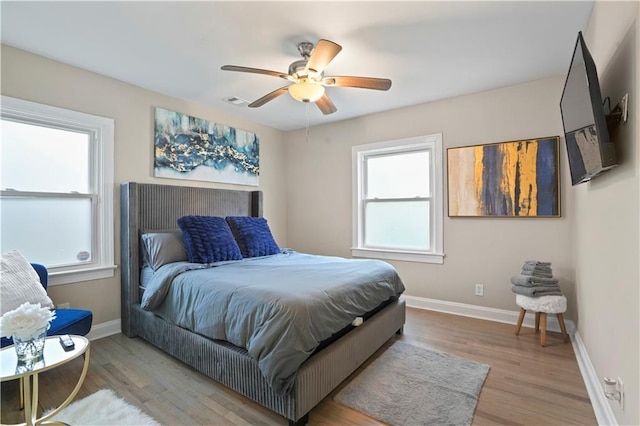 bedroom featuring ceiling fan, wood finished floors, and baseboards