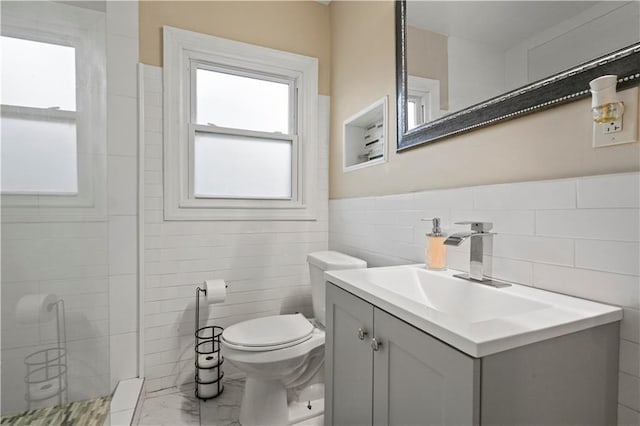 full bathroom featuring marble finish floor, tile walls, toilet, a stall shower, and vanity