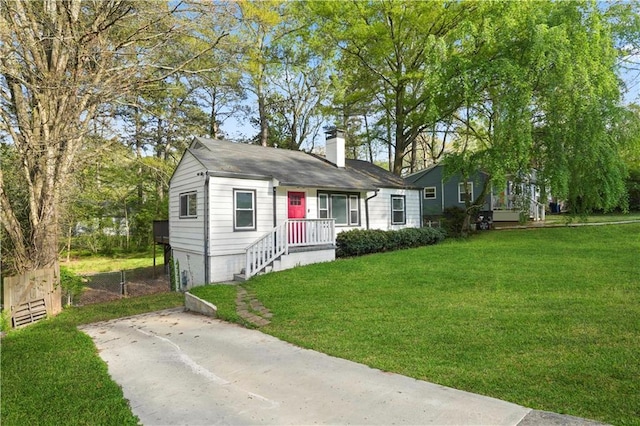 bungalow with fence, a chimney, and a front lawn