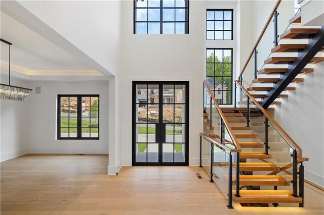 unfurnished living room featuring a high ceiling, a fireplace, and light hardwood / wood-style floors