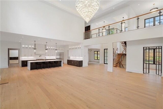 kitchen featuring sink, a notable chandelier, pendant lighting, a fireplace, and a kitchen island with sink