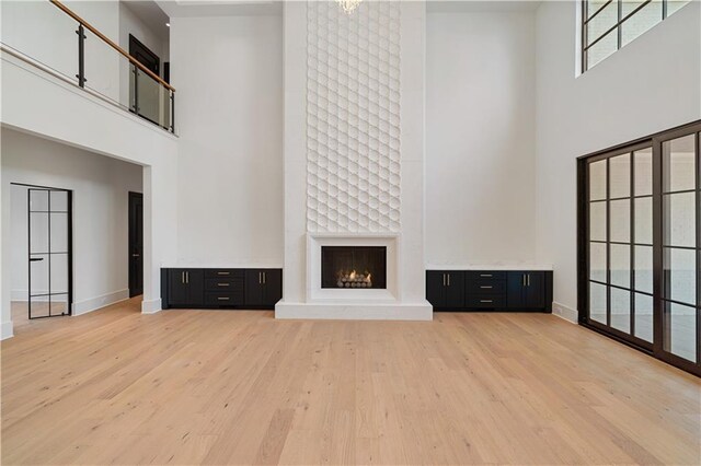 kitchen with pendant lighting, a fireplace, stainless steel dishwasher, and white cabinets