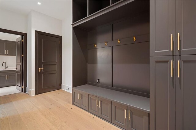 spacious closet with a notable chandelier and light hardwood / wood-style floors