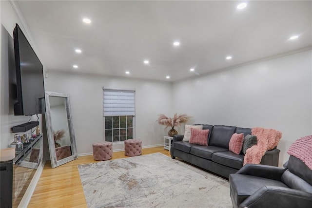 living area with light wood-type flooring, crown molding, baseboards, and recessed lighting