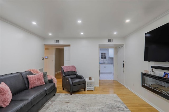 living area featuring light wood finished floors, visible vents, and recessed lighting