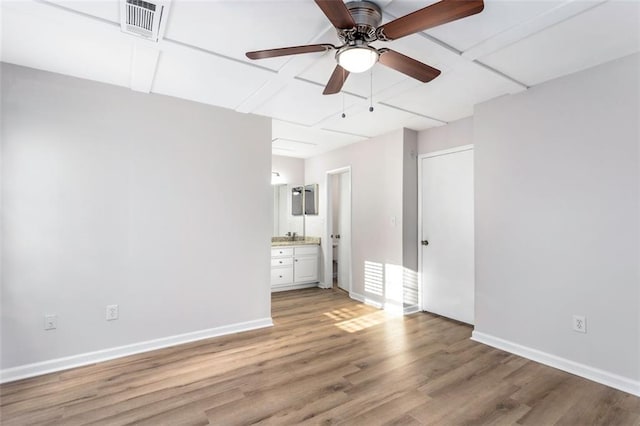 unfurnished living room featuring ceiling fan and hardwood / wood-style flooring