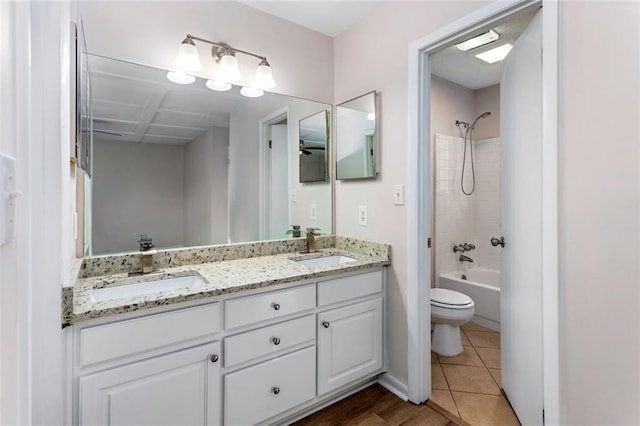 full bathroom with toilet, vanity, tile patterned flooring, and washtub / shower combination