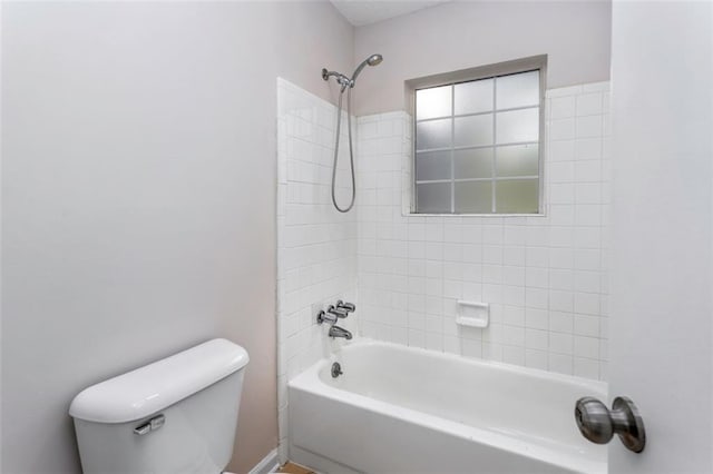 bathroom with toilet and tiled shower / bath combo