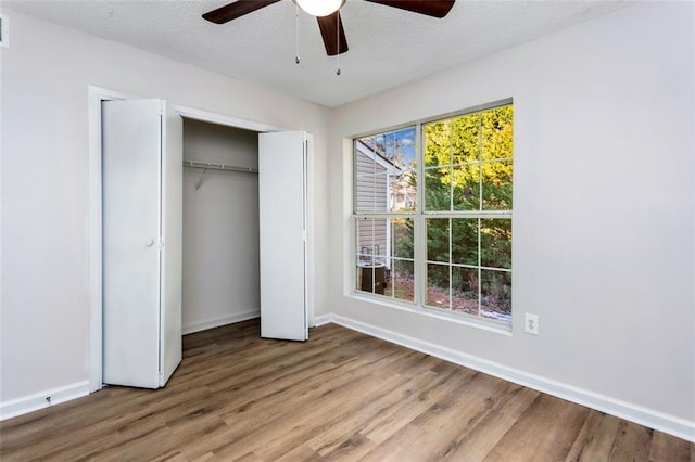 unfurnished bedroom with a textured ceiling, ceiling fan, and hardwood / wood-style flooring