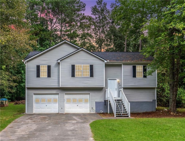 bi-level home featuring a front lawn, driveway, and an attached garage